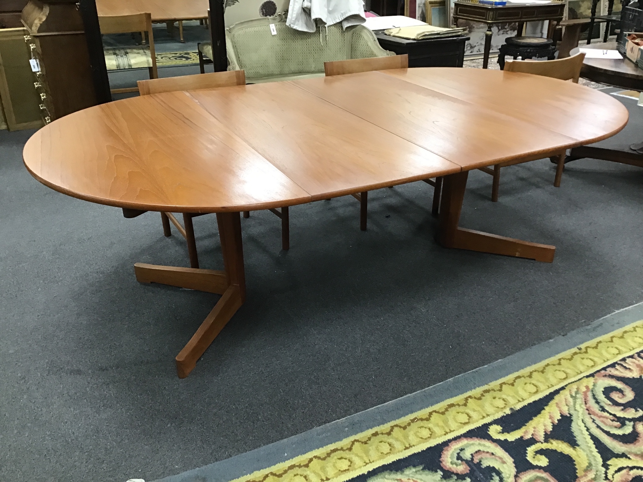 A 1950s teak Danish extending dining table and six chairs, two with arms, table extended 229cm, two spare leaves, width 129cm height 70cm